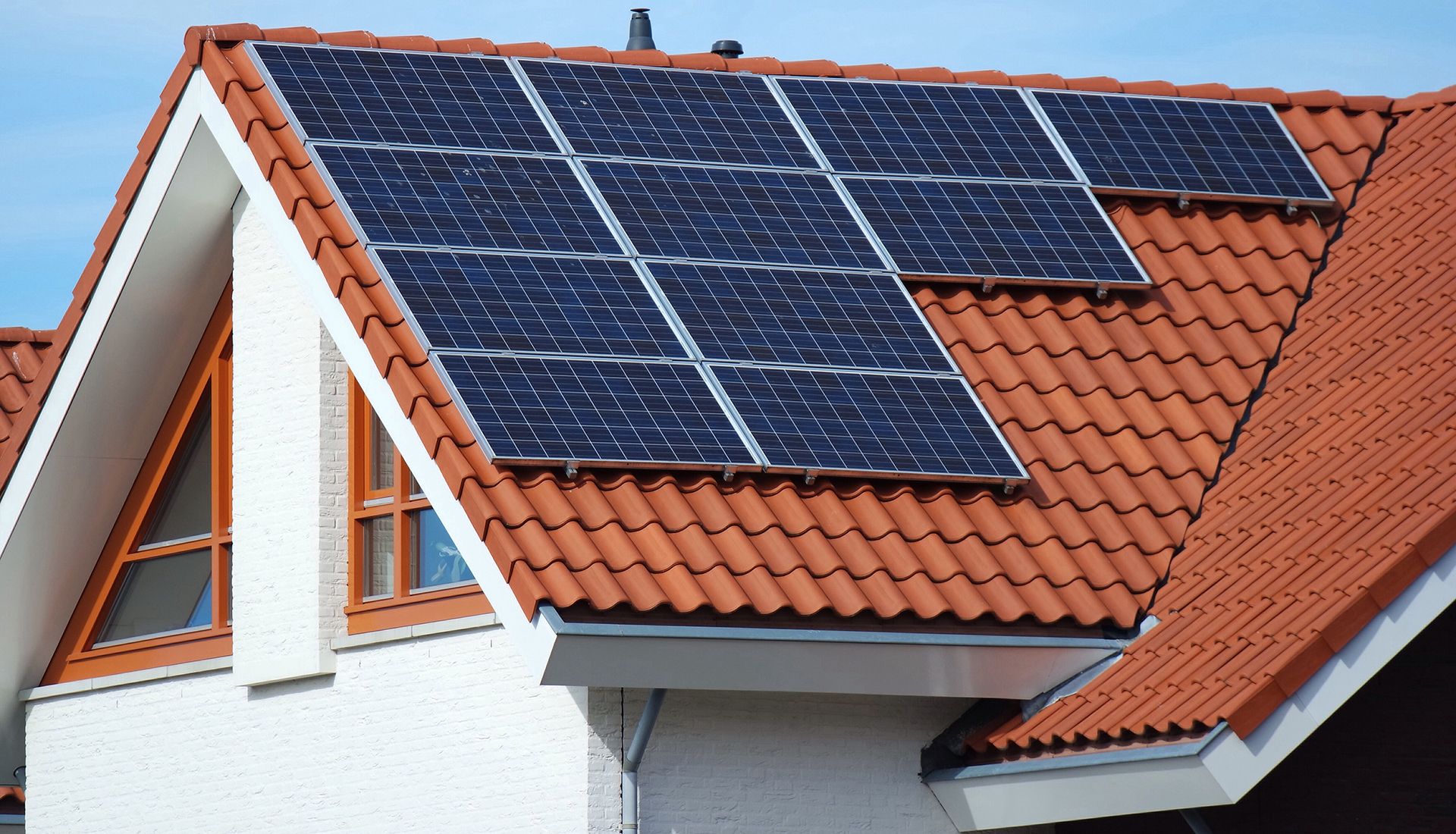 Placas solares en el tejado de una casa. Sistema de calefacción con energía solar.